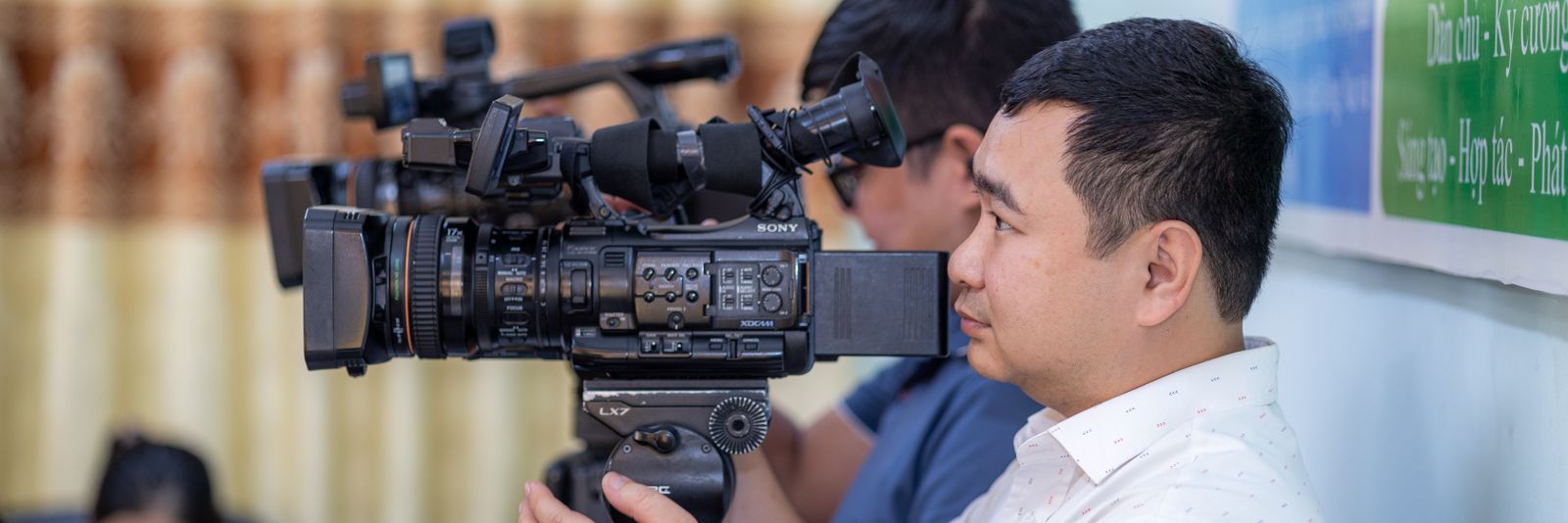 A broadcast camera operator filming an interview